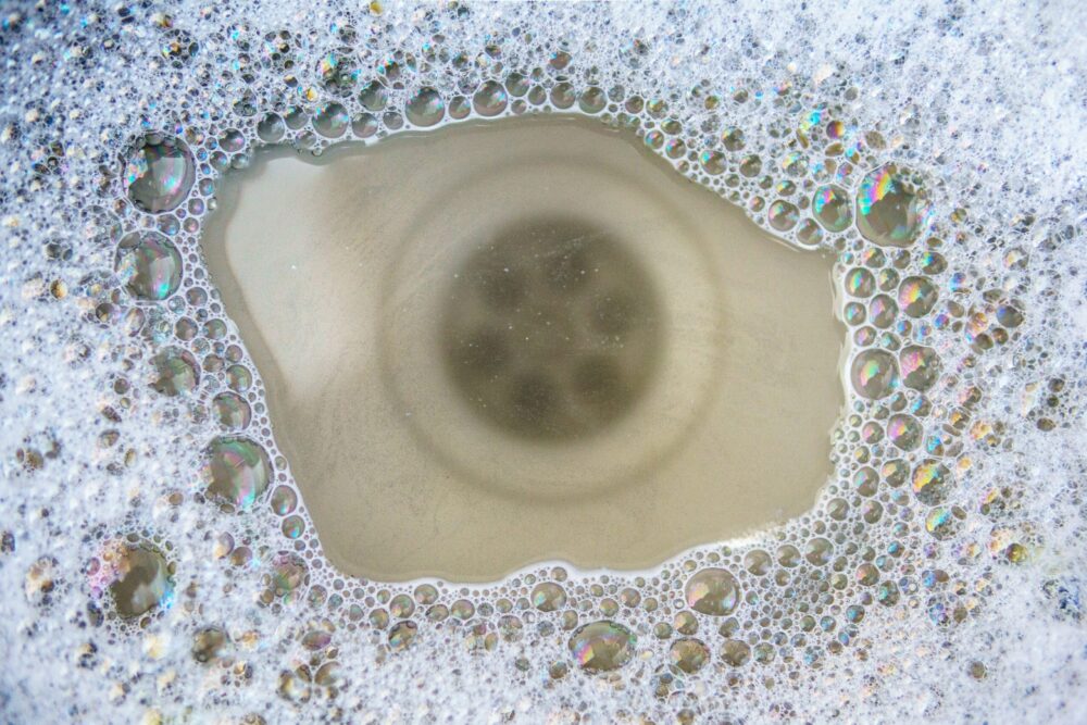 Close up of clogged kitchen sink with soapy water