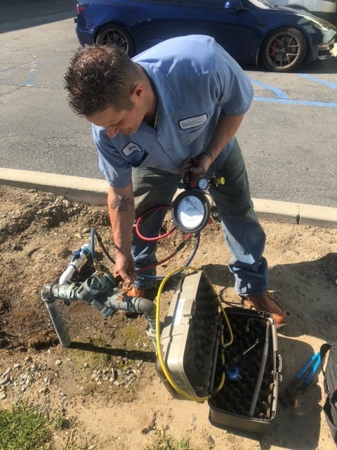 Technician performing backflow inspection